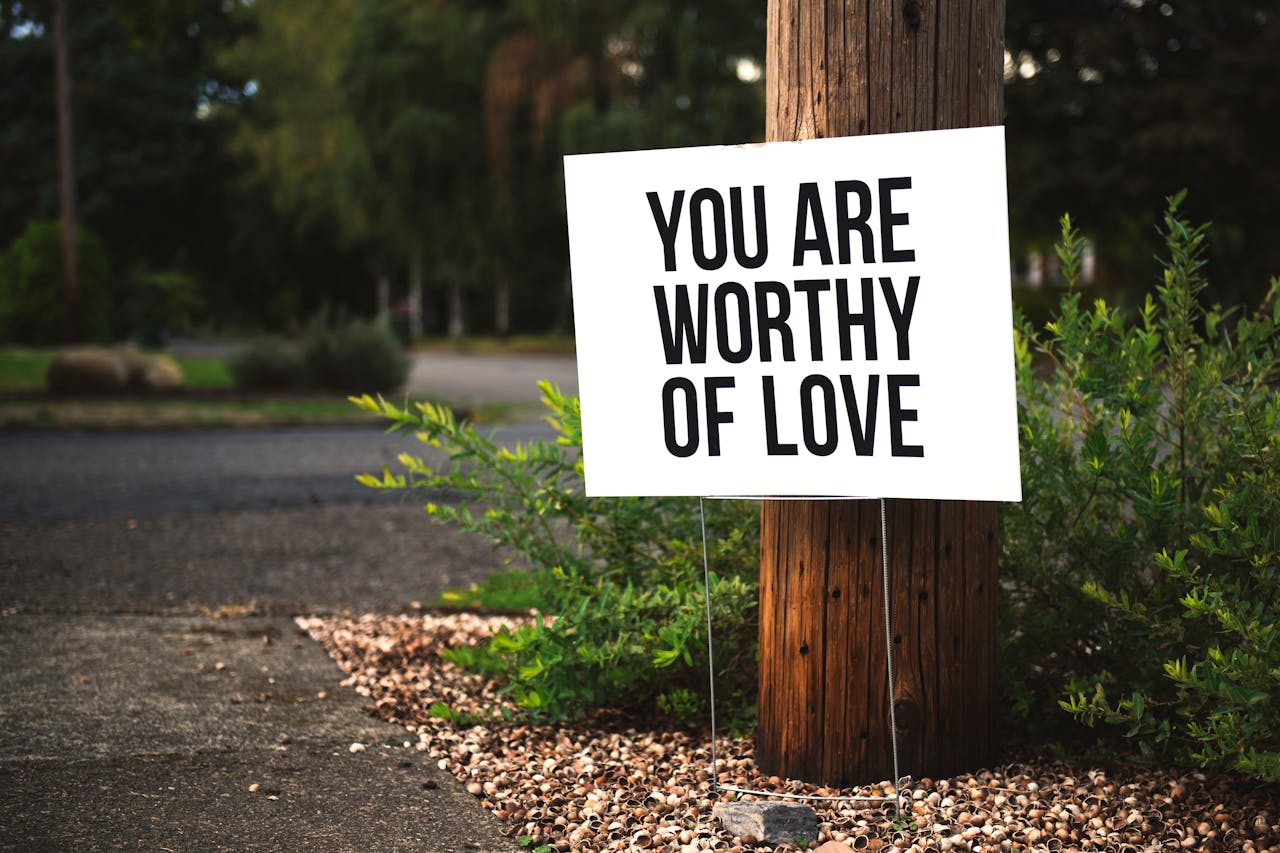 Services A positive message sign u0022You are worthy of loveu0022 in a park setting.